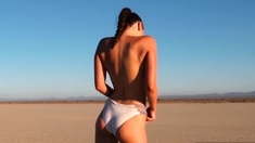 Curvy petite brunette strips at a beach