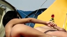 Brunette gives a handjob on a nudist beach